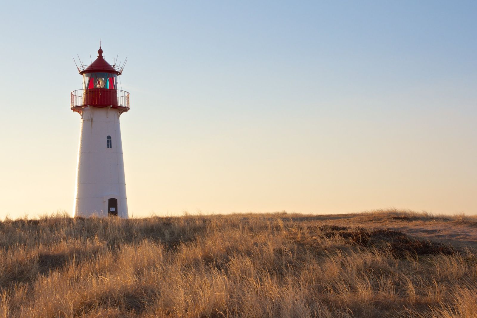 Leuchtturm in den Dünen im Abendlicht